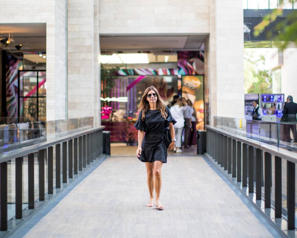 Casacostanera mujer caminando con vestido negro en pasillo interior